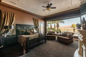 Bedroom featuring a ceiling fan, visible vents, dark carpet, and a textured ceiling