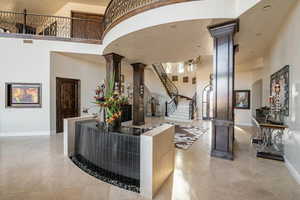 Interior space featuring ornate columns, arched walkways, and stairway