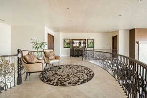 Interior space with an upstairs landing and a textured ceiling