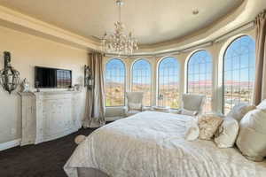 Bedroom with a notable chandelier, baseboards, and a raised ceiling