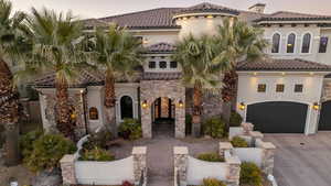 Mediterranean / spanish house with a tiled roof, stucco siding, and driveway