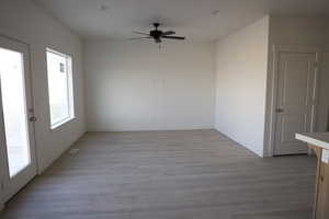 Unfurnished room with ceiling fan, baseboards, and light wood-style floors