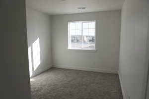 Unfurnished room with baseboards, visible vents, and carpet floors