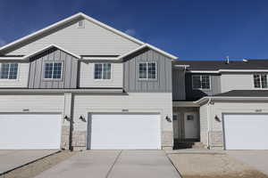 Multi unit property with stone siding, board and batten siding, driveway, and entry steps