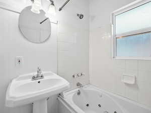 Bathroom with tiled shower / bath and sink