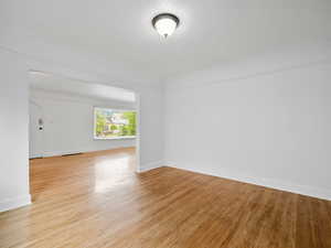 Empty room with light hardwood / wood-style floors and a textured ceiling