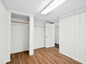 Unfurnished bedroom with wood-type flooring and a closet