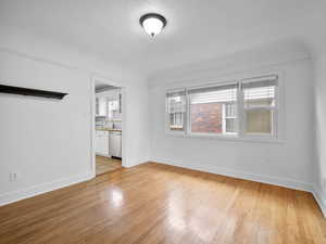 Empty room featuring sink, light hardwood / wood-style floors, and a textured ceiling