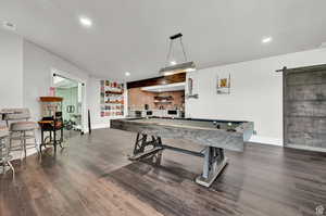 Playroom with billiards, baseboards, visible vents, a barn door, and dark wood-type flooring