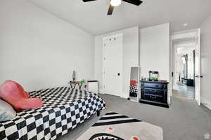 Carpeted bedroom featuring a ceiling fan