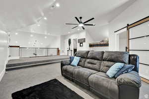 Living area featuring visible vents, light carpet, lofted ceiling, and a barn door