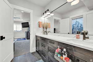 Full bath featuring a sink, baseboards, tile patterned flooring, and double vanity