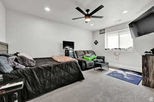 Carpeted bedroom with a ceiling fan, visible vents, recessed lighting, and a textured ceiling