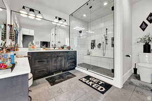 Bathroom featuring visible vents, vanity, toilet, and a stall shower