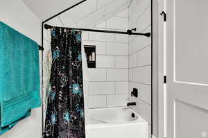 Bathroom with shower / bath combination with curtain