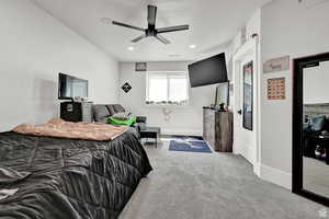 Bedroom featuring light colored carpet, ceiling fan, baseboards, and a textured ceiling