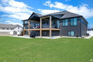 Back of house featuring stairs, a lawn, and fence