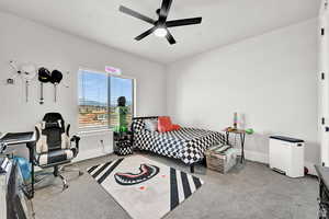 Bedroom featuring baseboards, ceiling fan, and carpet