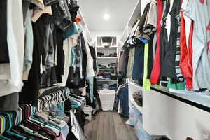 Walk in closet with wood finished floors