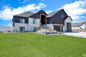 View of front of property with a front lawn, driveway, and board and batten siding