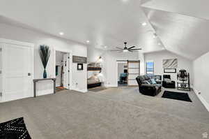 Carpeted living room featuring recessed lighting, a barn door, a textured ceiling, ceiling fan, and vaulted ceiling