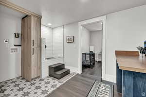 Bathroom with baseboards, a textured ceiling, and wood finished floors