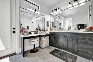 Bathroom with visible vents, vanity, and a tile shower