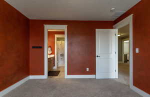 Unfurnished bedroom featuring light carpet and a textured ceiling