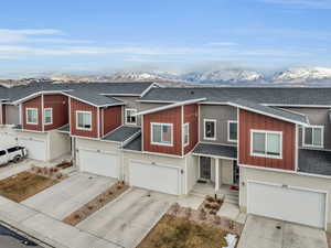 Townhome / multi-family property with a mountain view and a garage