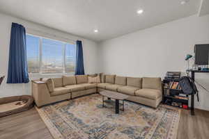 Living room with a textured ceiling and hardwood / wood-style floors