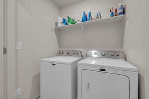 Clothes washing area featuring washing machine and clothes dryer