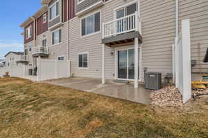 Back of property featuring a patio, cooling unit, and a yard