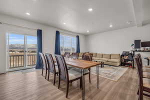 Dining area with light hardwood / wood-style flooring, a textured ceiling, and a healthy amount of sunlight