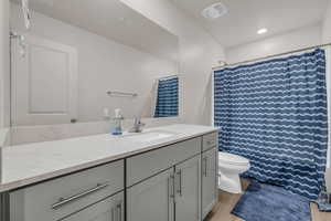 Bathroom featuring vanity, toilet, and hardwood / wood-style floors