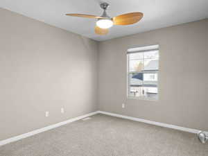 Carpeted spare room with ceiling fan