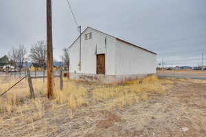 View of outdoor structure featuring an outbuilding and fence