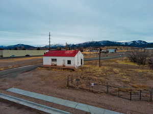 View of yard featuring fence, an outdoor structure, a mountain view, and a rural view