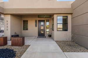 Doorway to property with stucco siding and a patio area