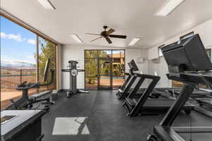 Workout area featuring expansive windows, a ceiling fan, and a textured ceiling