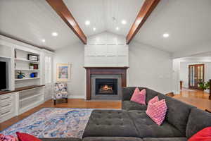 Living room featuring hardwood / wood-style flooring, lofted ceiling with beams, and french doors