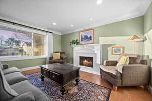 Living room with hardwood / wood-style floors and crown molding