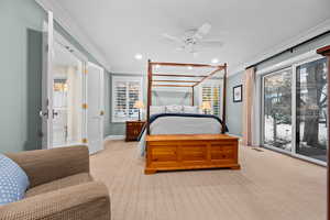 Carpeted bedroom featuring ceiling fan, access to outside, and ornamental molding