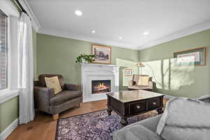 Living room with ornamental molding and hardwood / wood-style flooring