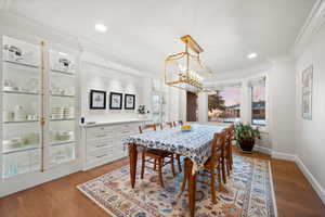 Dining room with a textured ceiling, crown molding, an inviting chandelier, and light hardwood / wood-style floors