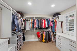 Spacious closet featuring light colored carpet