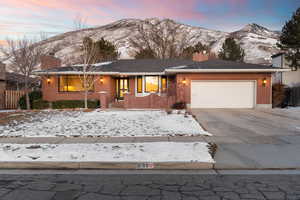 Ranch-style house with a garage and a mountain view