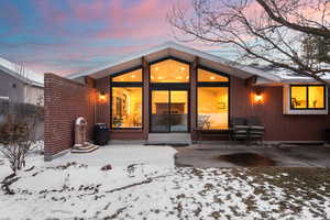 Snow covered property featuring a patio area