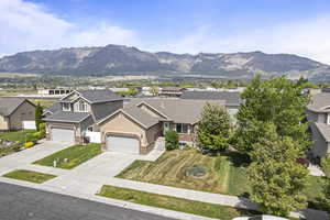 View of front of house featuring roof with shingles, a mountain view, driveway, a residential view, and stucco siding