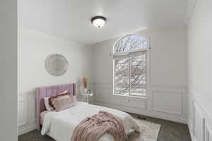 Bedroom featuring ornamental molding and dark colored carpet