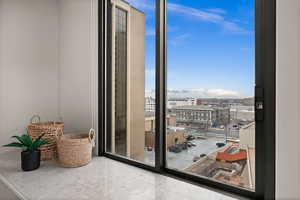 Interior space with light tile patterned flooring, a wall of windows, and a mountain view